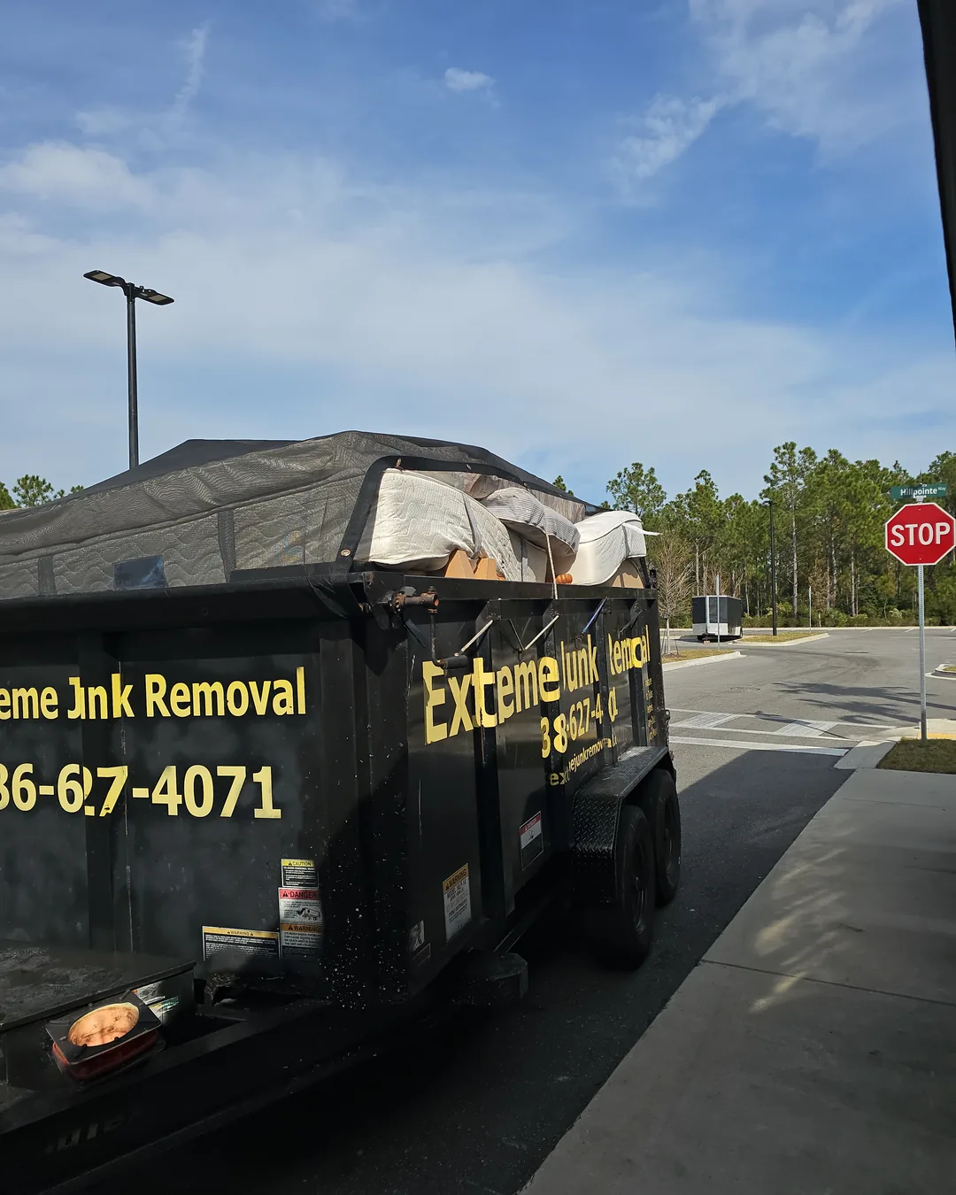 Office Cleanout Extreme Junk Removal dump trailer loaded and covered after a cleanout, serving Palm Coast to New Smyrna Beach