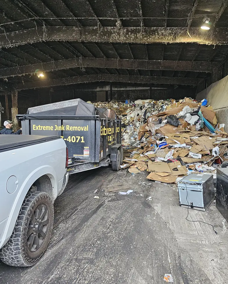 Extreme Junk Removal dump trailer unloading old appliances and junk at a waste transfer station