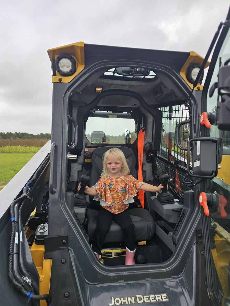 The youngest Extreme Junk Removal crew member in a skid steer